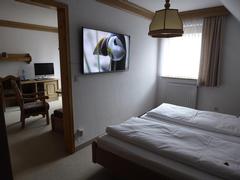 Blick vom Schlafzimmer mit riesigem LCD-Fernseher ins Wohnzimmer